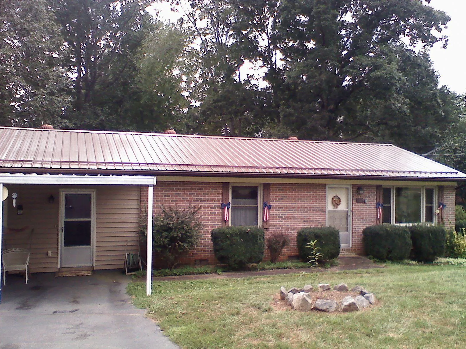 Bronze metal roof and carport on a brick ranch home — Roof Repair work by our crew in Rex